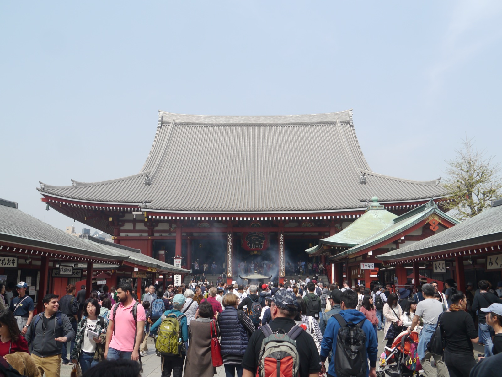 The broad tiled roof and red façade of Sensō-ji’s main hall, with visitors in the foreground.